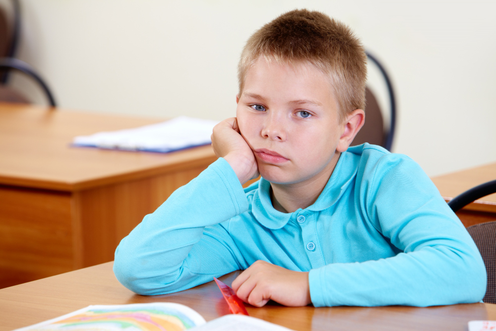 bored child at desk suddenly engaged with creative project on screen entrepreneurship KidStartupper